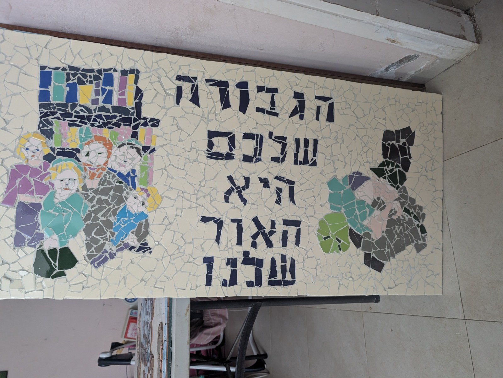 Handmade mosaic mural of a group of soldiers and a family, with Hebrew lettering
